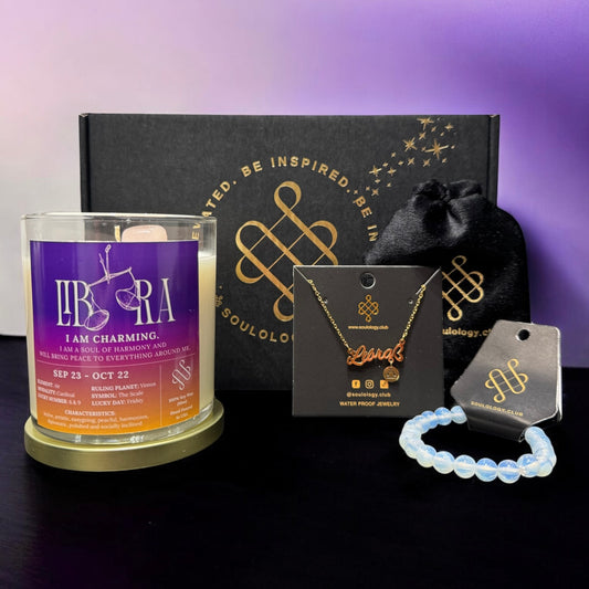 Scented candle, necklace, and bracelet with a branded box on a dark surface.