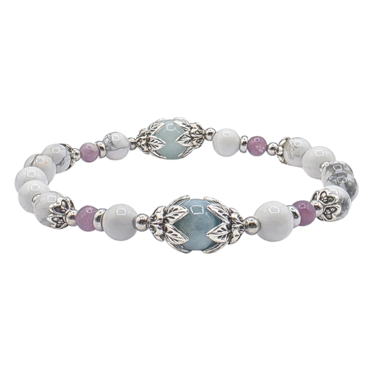 A beaded stretch bracelet featuring white and gray marbled beads, light blue oval center beads, small lavender-purple spacer beads, and ornate silver-toned metal filigree details, shown on a plain white background.